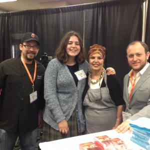 Four smiling people posing at exhibit booth
