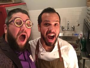 Two men in chef 's outfits are posing for a picture.