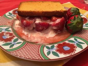 Strawberries and cream topped by cake slice