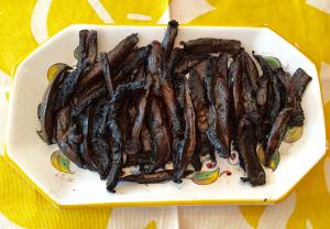 A white container filled with lots of black sticks.