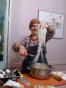 A woman is cooking some noodles in the kitchen.