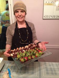 A woman holding a tray of food in front of her face.