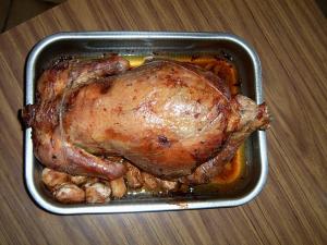 A turkey is sitting in the middle of a pan.