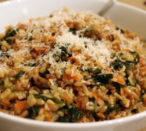 A bowl of rice with spinach and parmesan cheese.