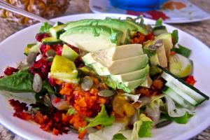 A salad with avocado and other vegetables on it.