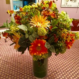 A vase filled with flowers on top of the floor.