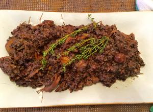 Braised beef with thyme on white platter