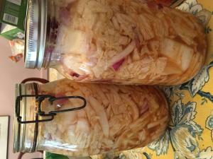 Two cats are sitting on a table together.