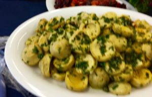 A plate of food with potatoes and parsley on it.