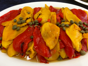 A plate of food with peppers and capers.