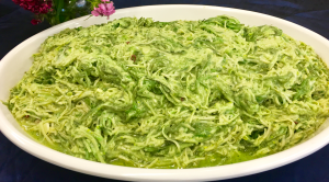 A bowl of green vegetables on top of a table.
