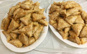 Golden sesame-topped phyllo pastry triangles on plates
