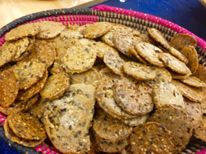 A basket of crackers with different flavors and toppings.