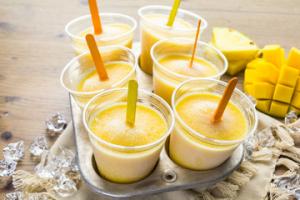 A tray of six cups filled with yellow liquid.
