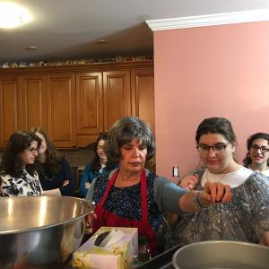 A group of people cooking in a kitchen.