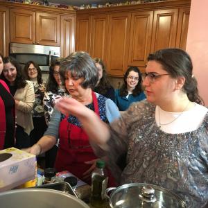 A group of people in the kitchen preparing food.