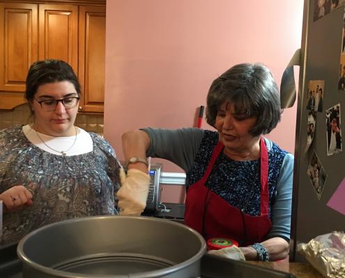 Woman in red apron prepping cake pan