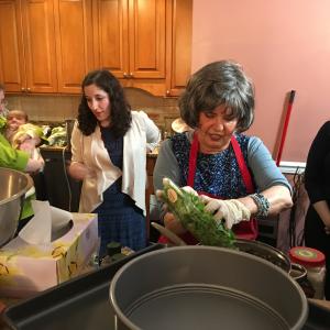 A group of people in the kitchen preparing food.