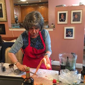 A woman in an apron is cutting food.