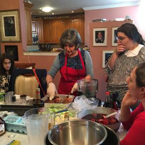 A group of people cooking food in a kitchen.