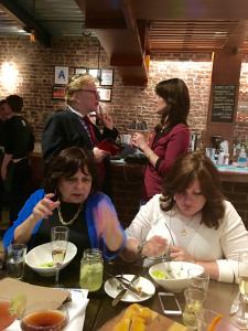 A group of people sitting at tables with plates.