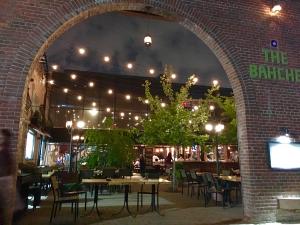 A restaurant with lights hanging from the ceiling.
