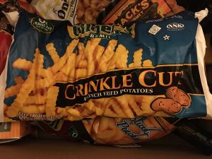 A bag of crinkle cut fries on top of a table.