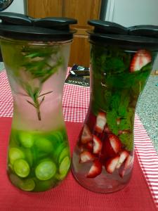 Two glasses with fruit inside of them on a table.