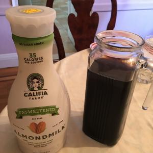A bottle of sauce and a jar on the table.