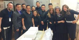 Smiling catering team posing in kitchen
