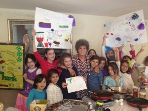 Children showing colorful handmade posters in kitchen