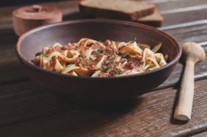 Wooden bowl of tagliatelle with ragu