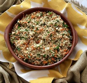 Bowl of couscous salad with carrots and herbs