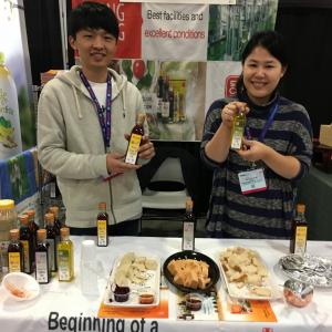 Two people standing at a table with food.