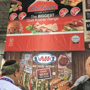 A man standing next to a woman in front of an advertisement.