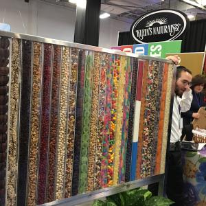 A man standing next to a wall covered in colorful papers.