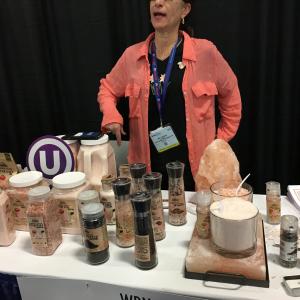 A woman standing at a table with many different items.