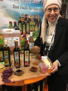 A man standing next to some bottles of olive oil.