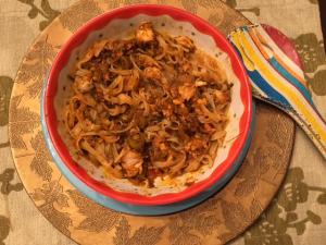 Spicy saucy noodles in colorful ceramic bowl