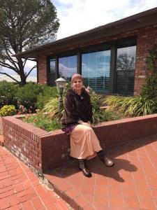 A woman sitting on the ground in front of a building.