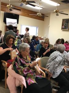 A group of people sitting in chairs and talking.