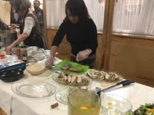 A woman is cutting food on the table.