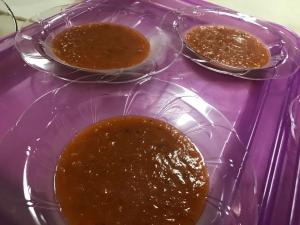Three bowls of food on a purple tray.