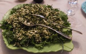 A plate of food with greens and silverware on it.