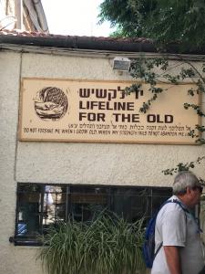A man walking in front of a building with a sign on it.