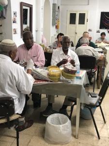 Men preparing meals at a communal table