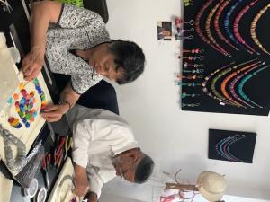 Two people making colorful handmade beaded jewelry