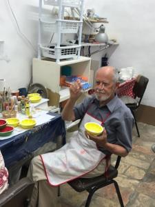 A man sitting in a chair holding two bowls.