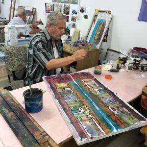 A man sitting at a table in front of a painting.