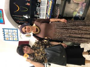 Two women posing in colorful artisan jewelry boutique